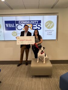 Attorney Ben Whitley presenting a charitable donation check to Jennifer Federico, Director of Animal Services for Wake County and her dog