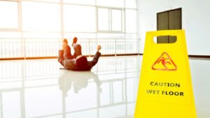 Man Slipping on Wet Floor with Warning Sign Slippery