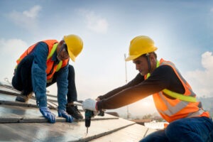 Construction workers on a roof. Find out how to get compensation with a Southern Pines construction accident lawyer.