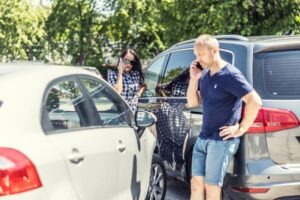 A man and a woman after a crash. A lawyer can explain what happens when a car accident claim exceeds insurance limits.